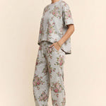 Person wearing a floral outfit with a plain background