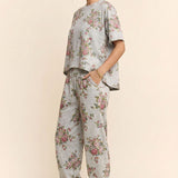 Person wearing a floral outfit with a plain background