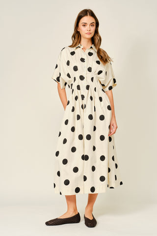 Woman wearing a polka dot dress on a white background