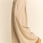 Beige wide-leg pants worn by a person on a plain background