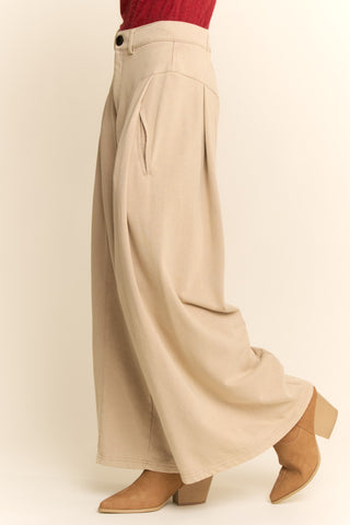 Beige wide-leg pants worn by a person on a plain background