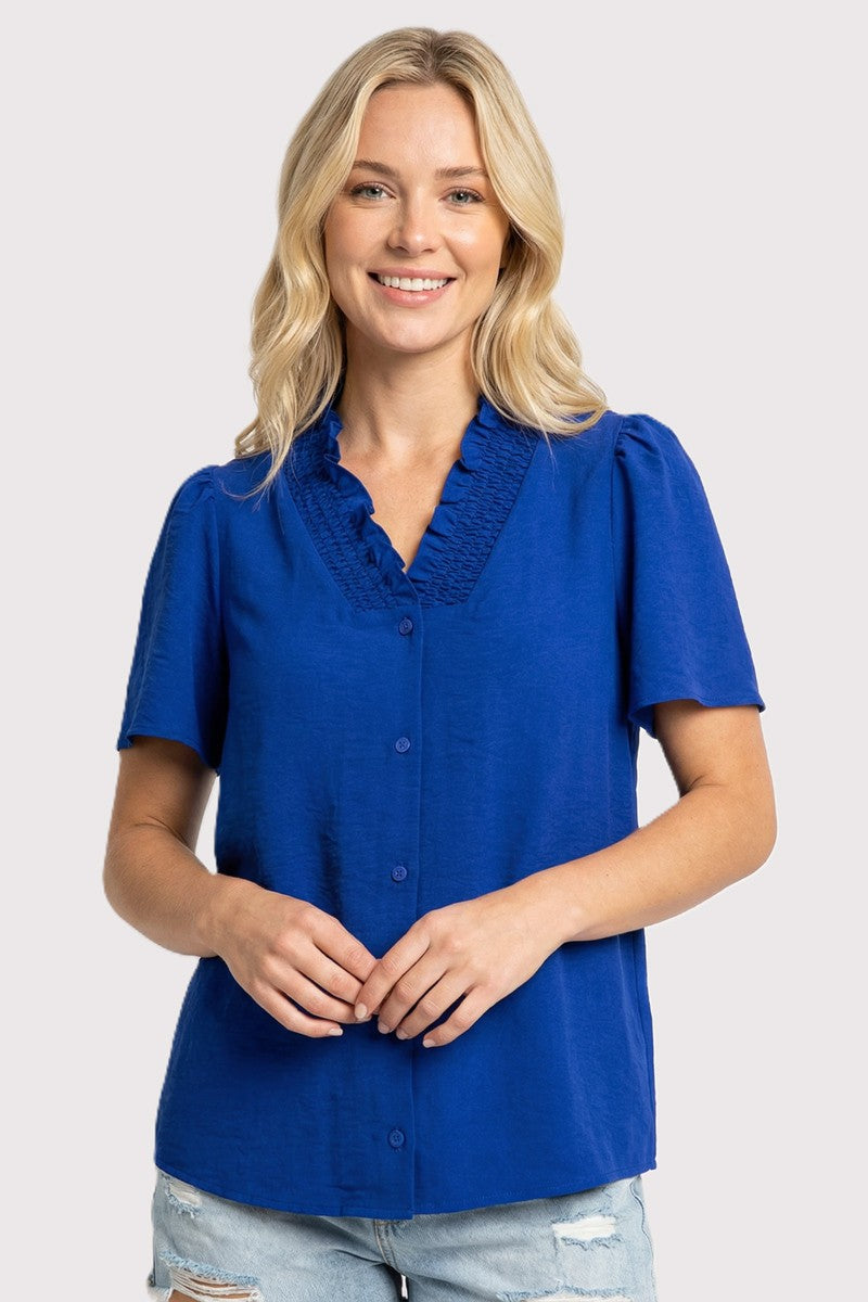 Woman wearing a blue blouse with lace details on a white background