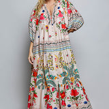 Woman wearing a colorful floral dress on a gray background