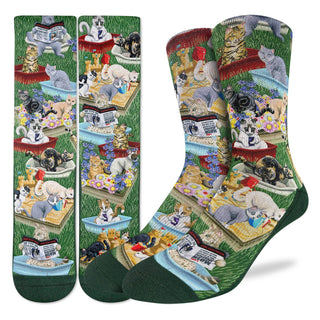 Colorful socks with a pattern of cats in various activities on a grassy background.