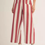 Red and white striped pants worn by a person on a beige background
