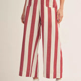 Red and white striped pants worn by a person on a beige background