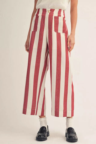 Red and white striped pants worn by a person on a beige background