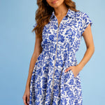 Woman wearing a blue floral dress against a light blue background