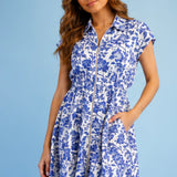 Woman wearing a blue floral dress against a light blue background