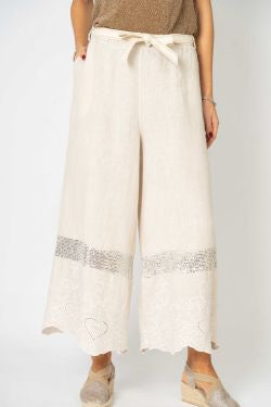 White wide-leg pants with decorative trim on a white background