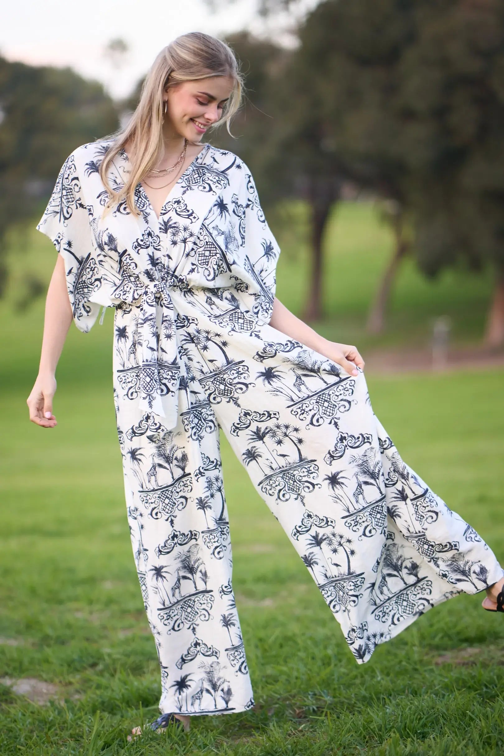 Woman wearing a white outfit with black patterns in a park