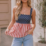 Woman wearing a red, white, and blue striped dress with a patterned top outdoors.