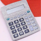 Silver calculator with blue buttons on a pink background
