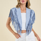 Woman wearing a light blue fringe jacket over a white top and pants on a beige background