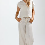 Woman wearing a sleeveless top and striped pants on a white background