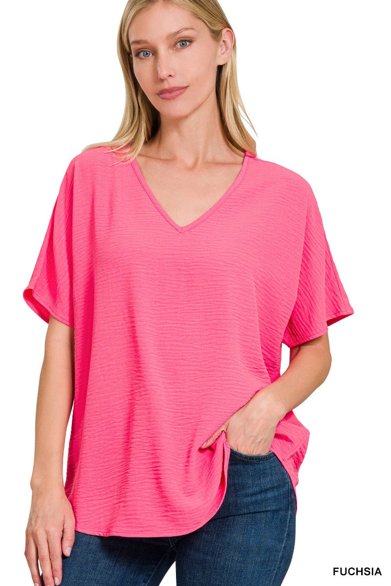 Woman wearing a pink oversized t-shirt with text 'Fuchsia' on a white background