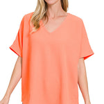 Woman wearing a coral-colored top on a white background
