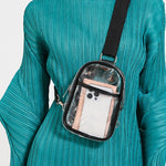 Person wearing a teal dress with a transparent crossbody bag.