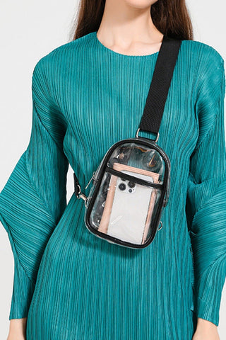Person wearing a teal dress with a transparent crossbody bag.