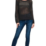 Woman wearing a black sheer top and blue jeans on a white background