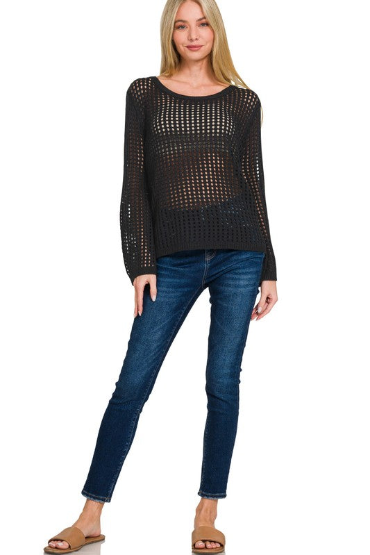 Woman wearing a black sheer top and blue jeans on a white background