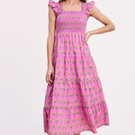 Woman wearing a pink dress with floral pattern on a white background