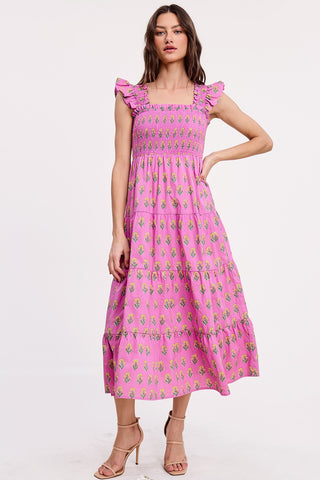 Woman wearing a pink dress with floral pattern on a white background
