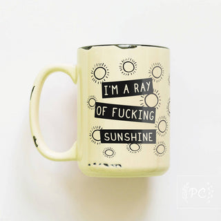 Yellow mug with black text and sun designs on a white background