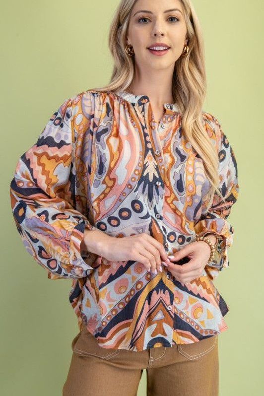Woman wearing a patterned blouse against a green background
