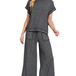 Woman wearing a gray outfit with wide-leg pants on a white background