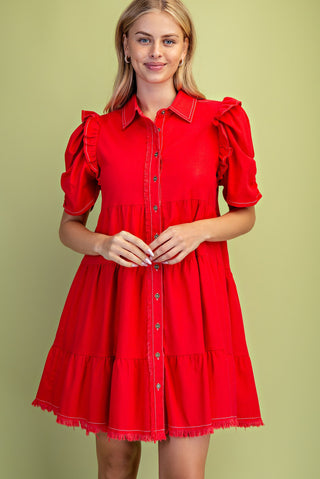 Woman wearing a red dress with puff sleeves against a green background