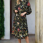 Woman wearing a floral dress standing in an outdoor setting.