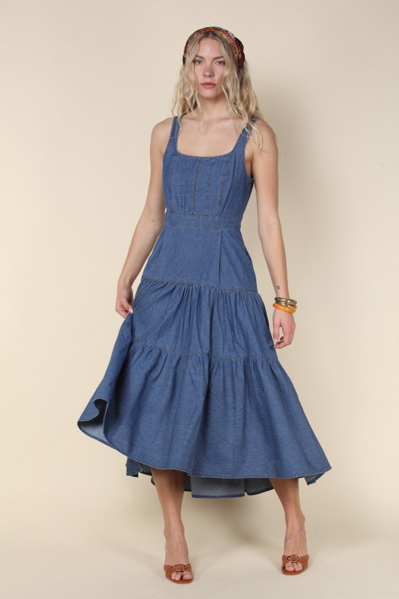 Woman wearing a blue dress against a beige background