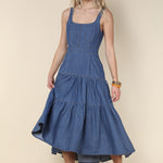 Woman wearing a blue dress against a beige background