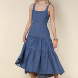 Woman wearing a blue dress against a beige background