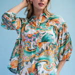 Woman wearing a colorful patterned blouse against a blue background