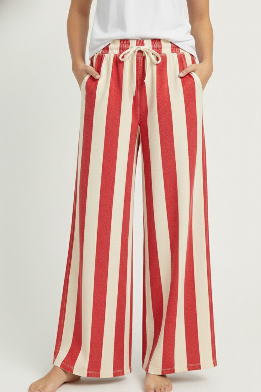 Red and white striped pants worn by a person on a plain background