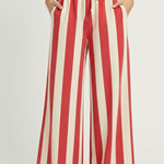 Red and white striped pants worn by a person on a plain background