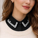 Woman wearing a black blouse with a decorative collar