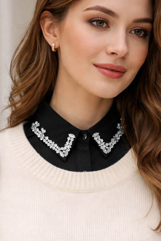 Woman wearing a black blouse with a decorative collar