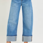 Blue jeans with rolled-up cuffs on a white background