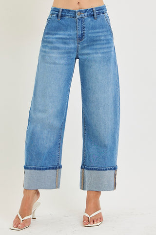 Blue jeans with rolled-up cuffs on a white background