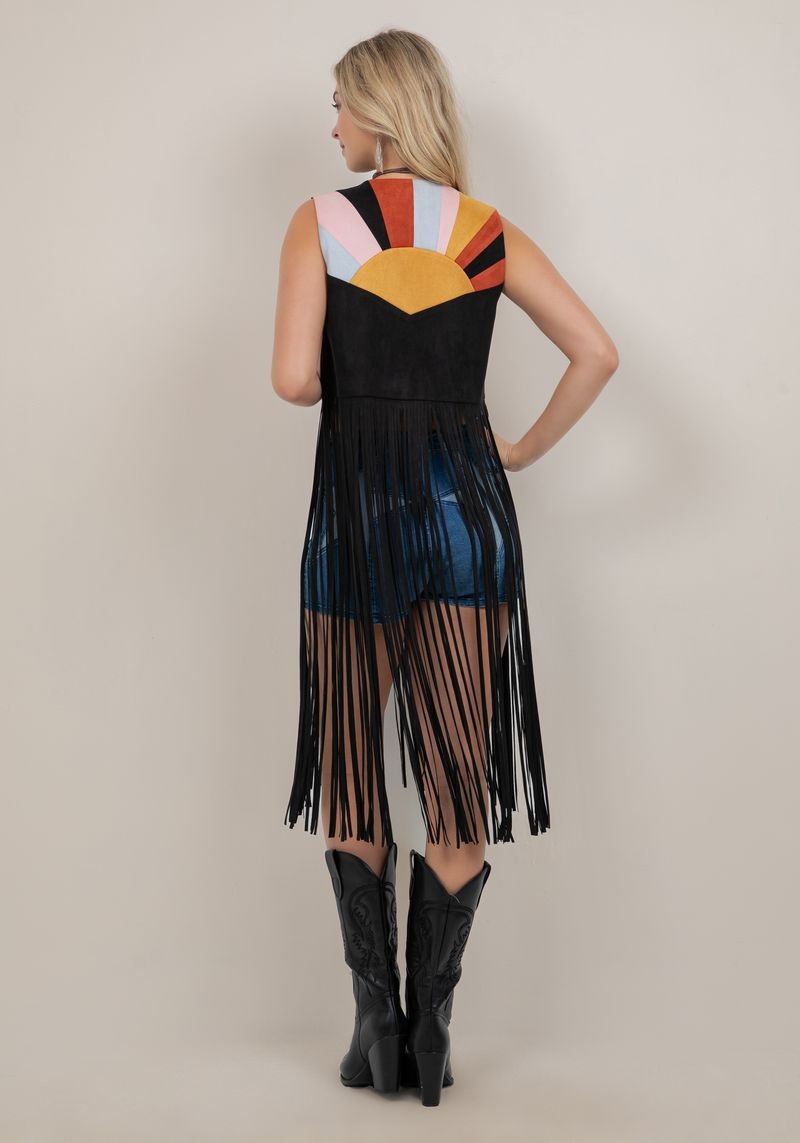 Woman wearing a colorful sleeveless dress with fringe details on a plain background