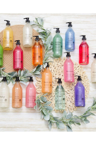 Assorted colorful bottles on a decorative background with greenery