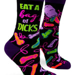 A pair of women's novelty crew socks with a colorful and playful design, featuring the phrase 'EAT A BAG OF DICKS' in bold letters alongside various stylized graphics.