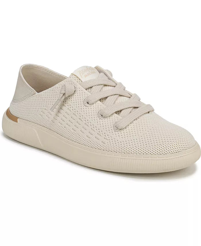 A single low-top sneaker in a light cream or off-white color, featuring a textured perforated mesh upper, matching flat laces, and a thick ribbed sole, shown against a plain white background.