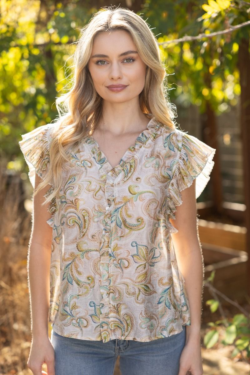 Woman wearing a floral blouse with ruffled sleeves outdoors
