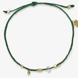 Green bracelet with gold accents on a white background