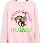 Pink sweatshirt with 'Beverly Hills Rodeo' graphic on a hanger against a white background