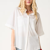 Woman wearing a white oversized shirt and blue jeans on a white background